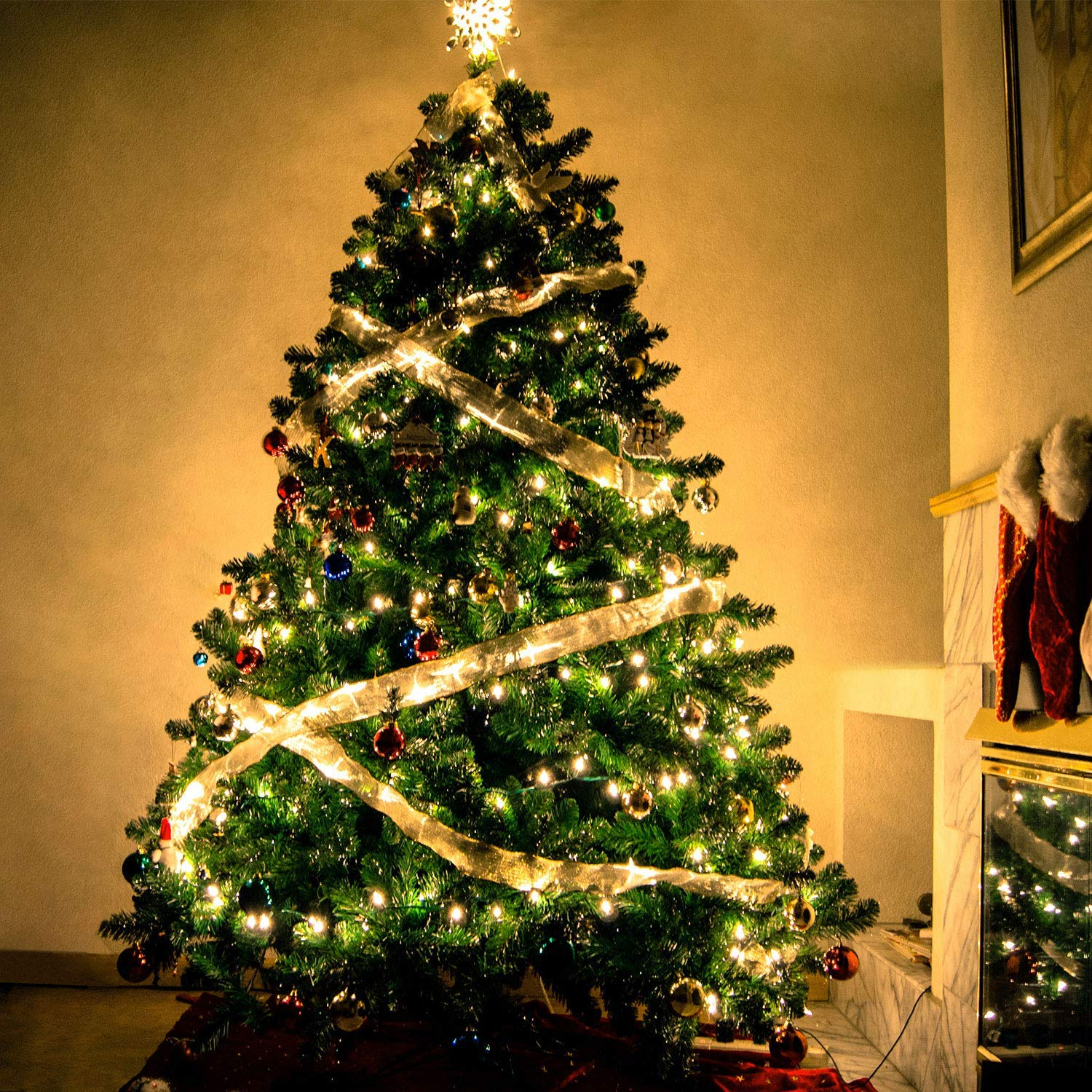 Geschmückter Weihnachtsbaum mit Lichtern, Ornamenten und Stern, mit Kamin.