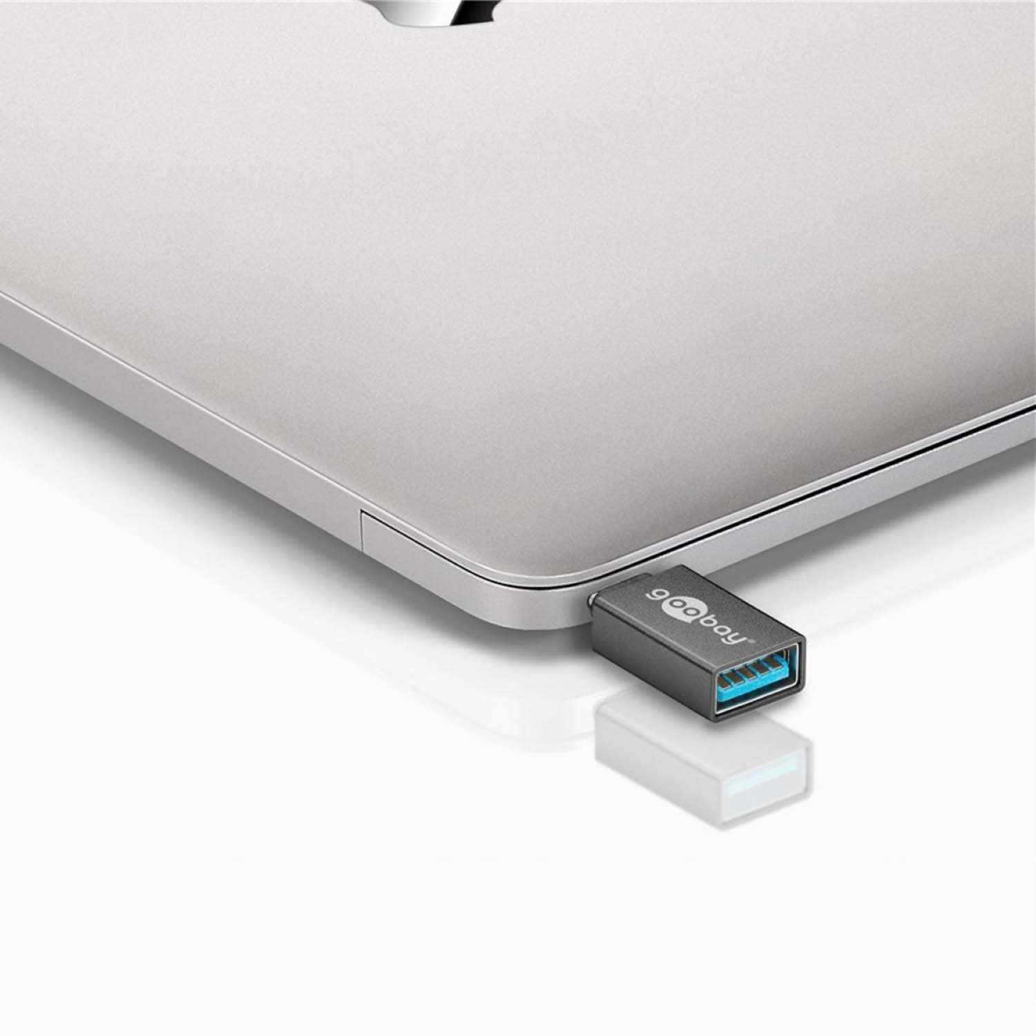 Laptop argentato con un piccolo adattatore USB collegato.