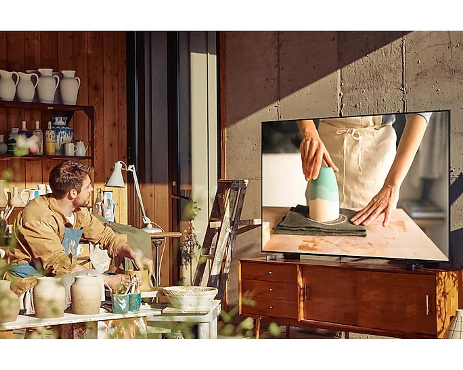 Mężczyzna ogląda TV, osoba pracuje nad ceramiką na ekranie, brązowe meble.
