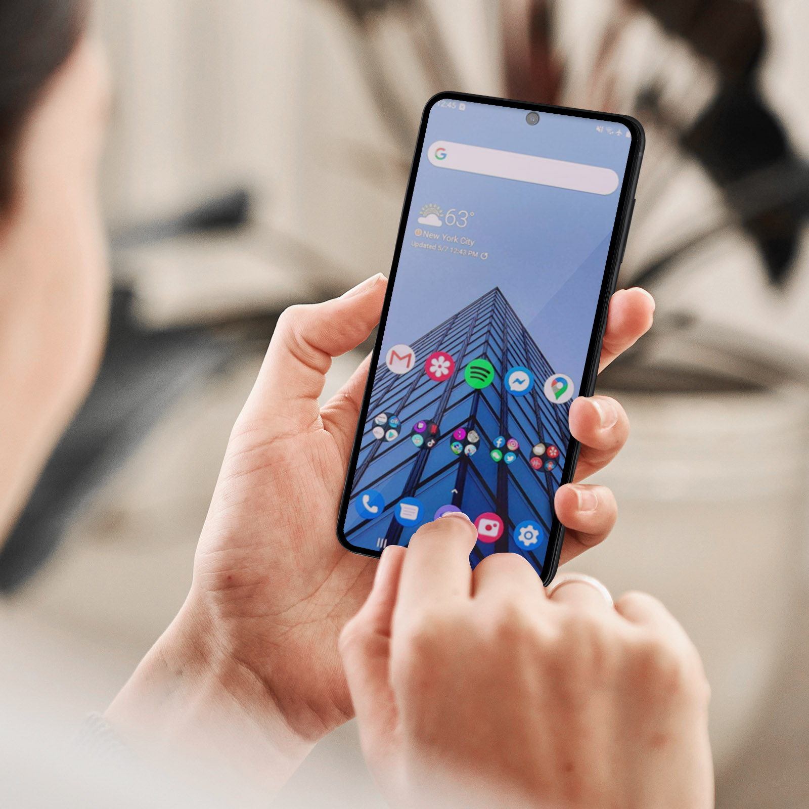 Una persona che tiene in mano un telefono con una vista della città sullo schermo. Ci sono icone di app sullo schermo.