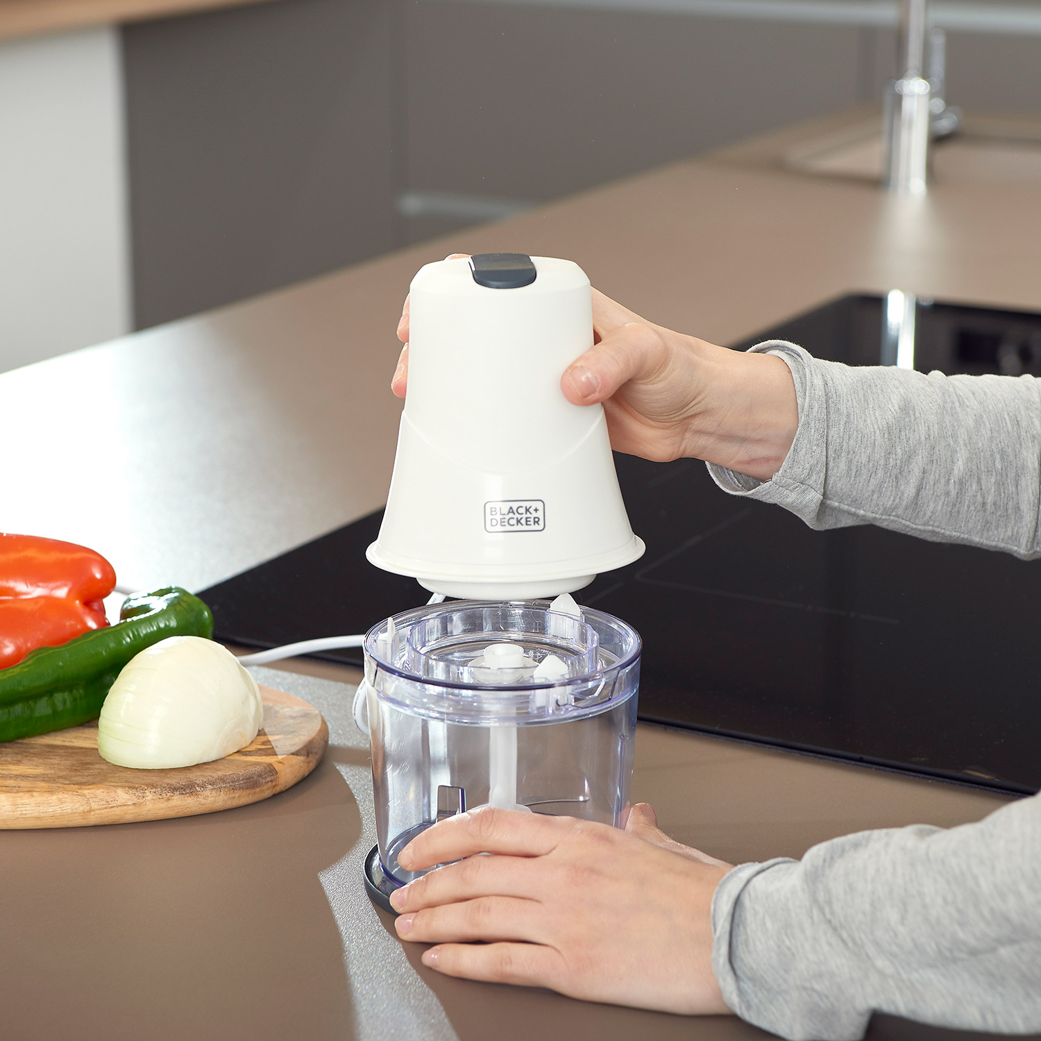 Mani che assemblano un mini tritatutto bianco BLACK+DECKER.