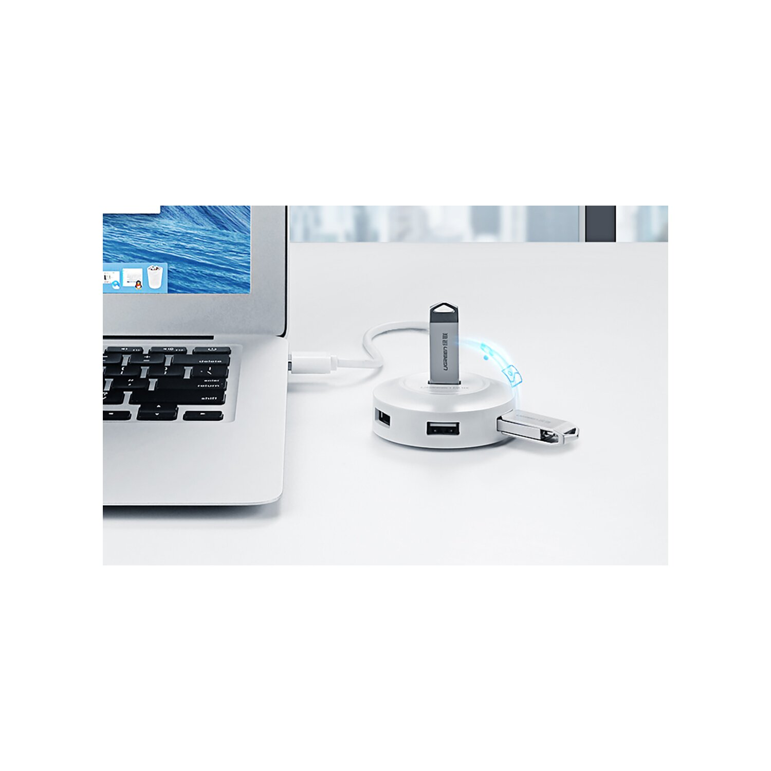 Ein USB-Hub mit angeschlossenem USB-Stick, in der Nähe eines Laptops. Weißer Hintergrund.