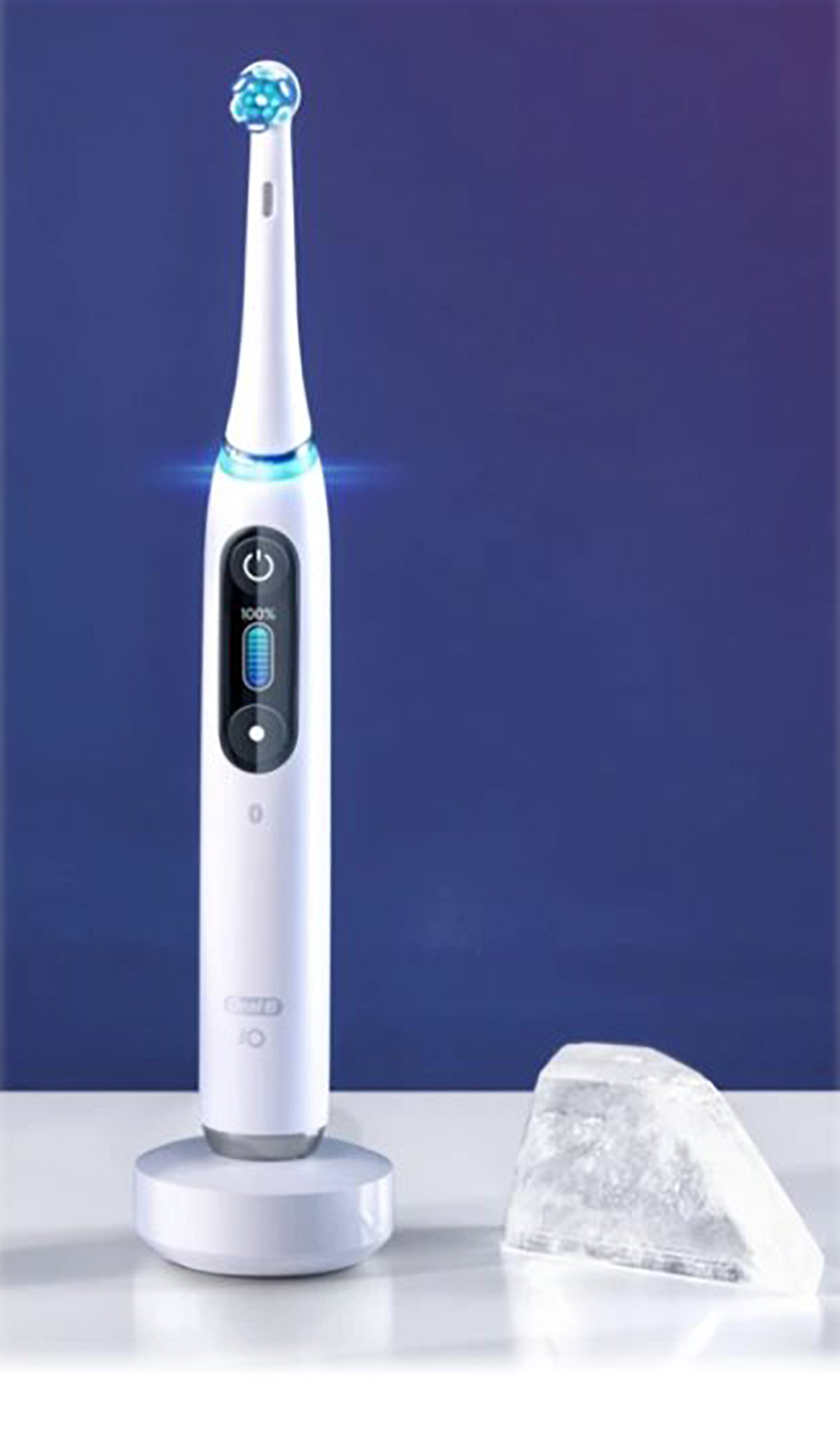 Spazzolino elettrico bianco su un supporto, sfondo blu e ghiaccio.