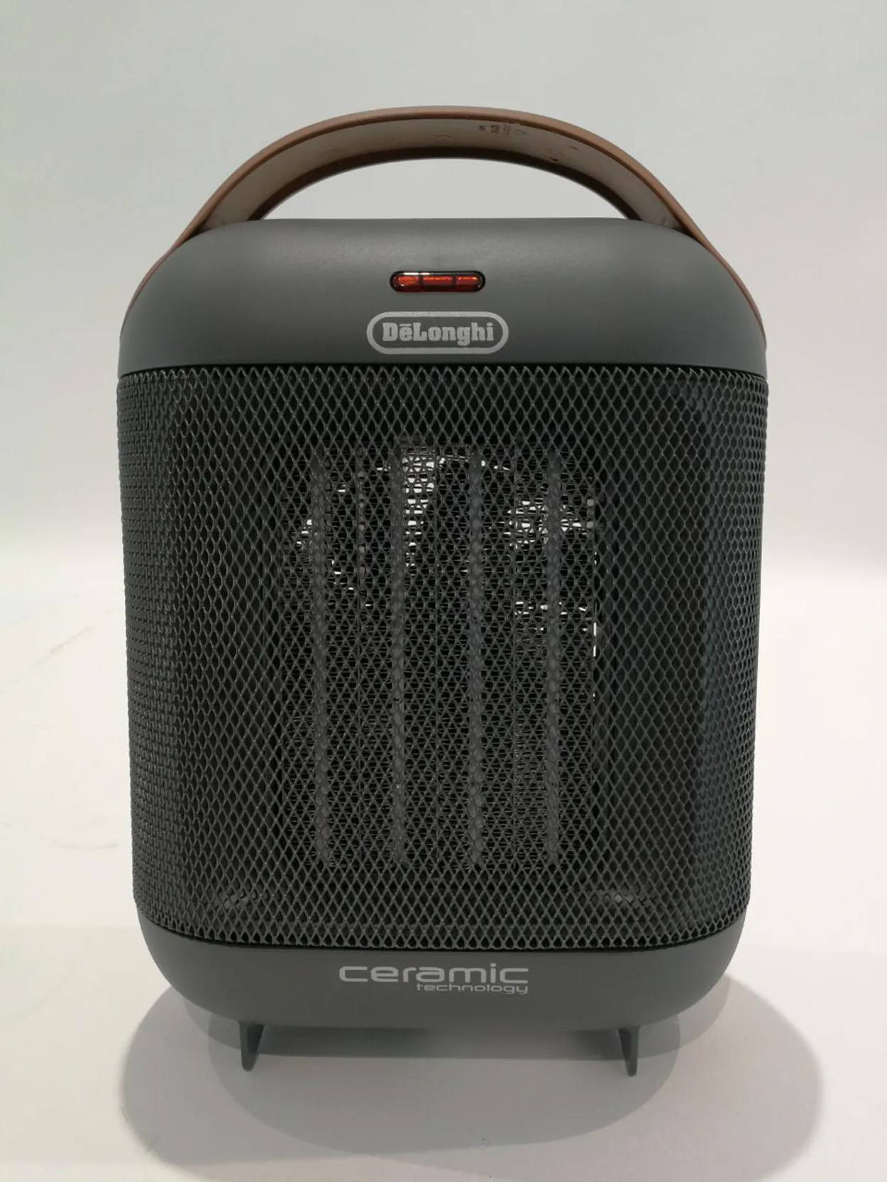 Szary grzejnik ceramiczny z uchwytem na białej powierzchni.