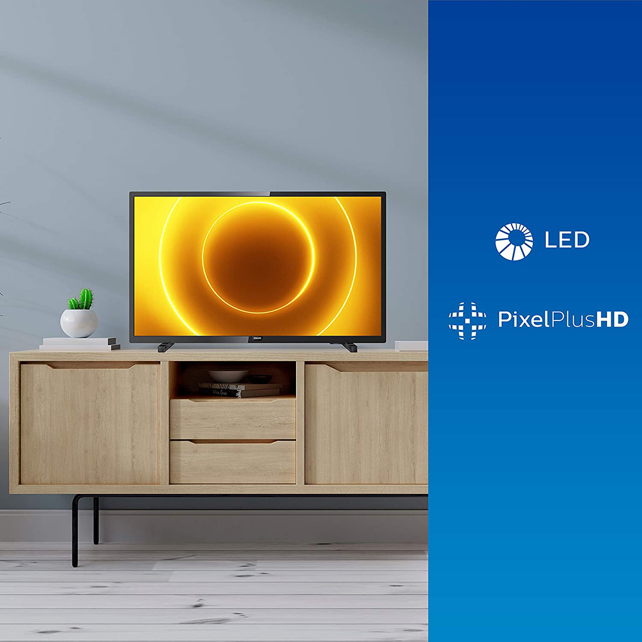 TV con anello giallo sul display, su mobile in legno, con loghi LED e PixelPlusHD.