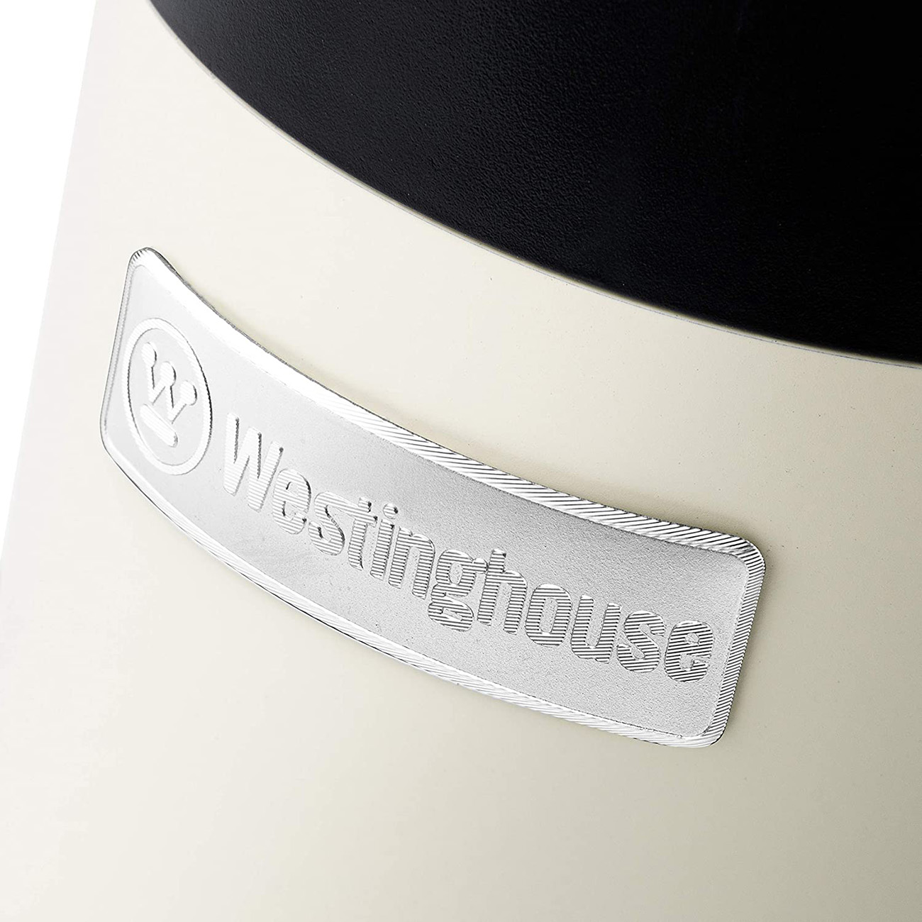 Cremefarbenes Gerät mit dem Westinghouse-Logo. Glänzendes silbernes Logo auf einem geschwungenen, erhabenen Bereich.