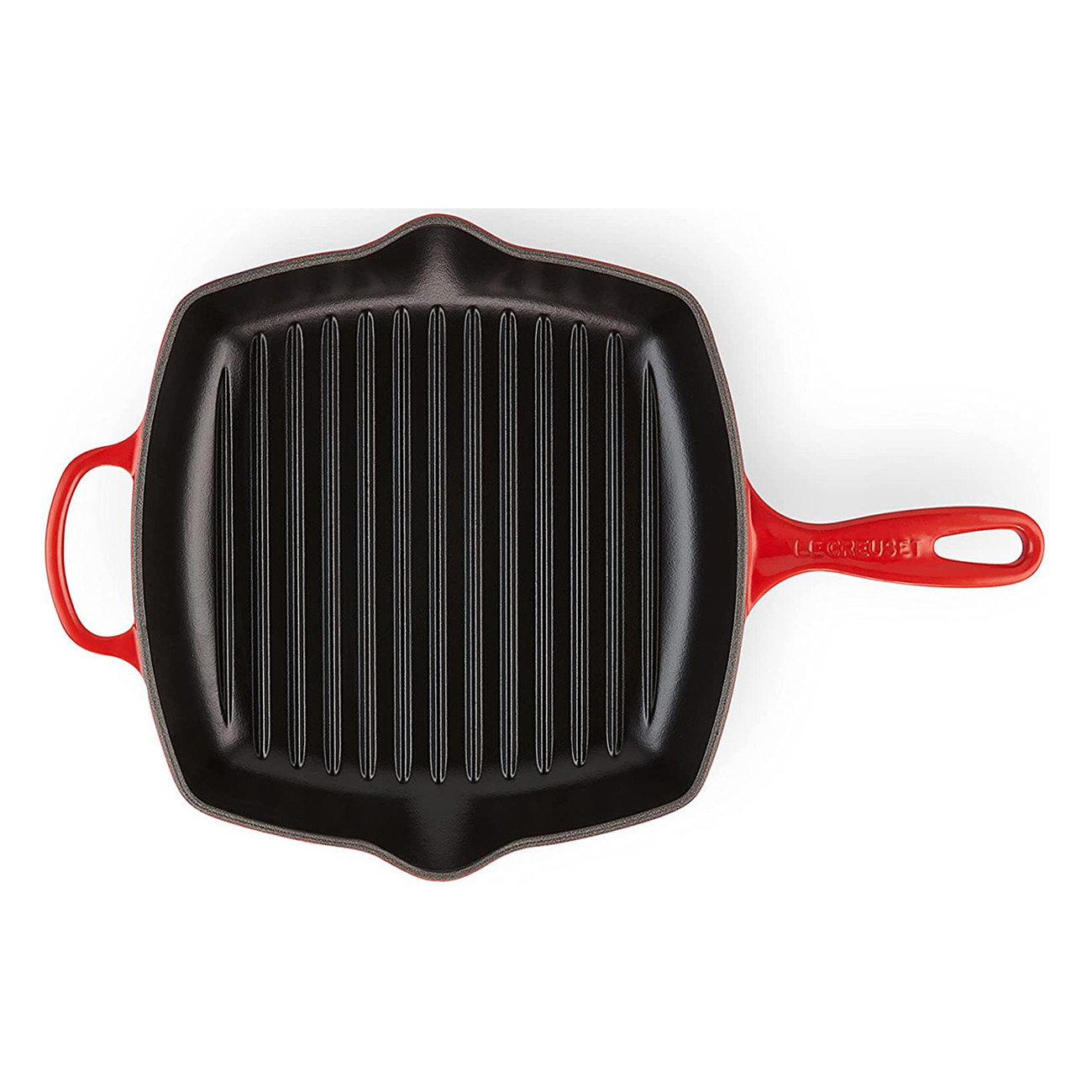 Une poêle grill Le Creuset rouge. La poêle est noire et possède un intérieur nervuré avec une poignée.