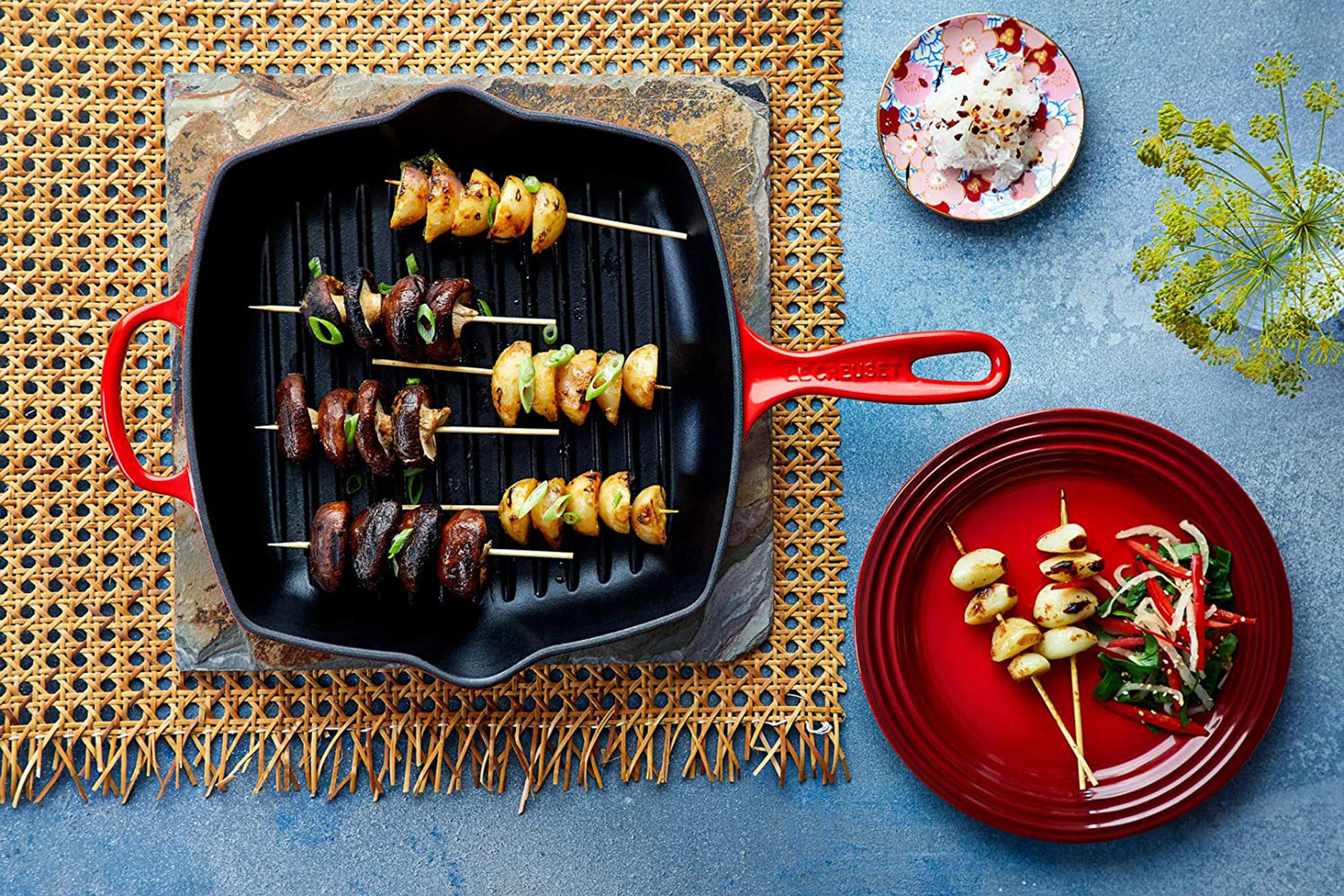 Aliments grillés sur des brochettes dans une poêle noire. Comprend champignons, pommes de terre et oignons.