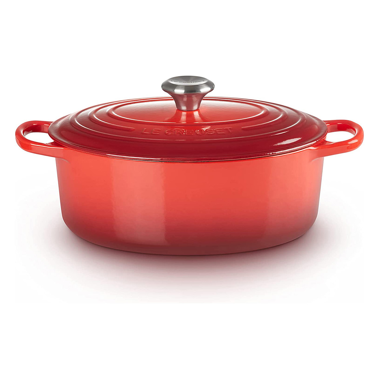 Pentola olandese Le Creuset rossa con manici e coperchio. La pentola è su sfondo bianco.