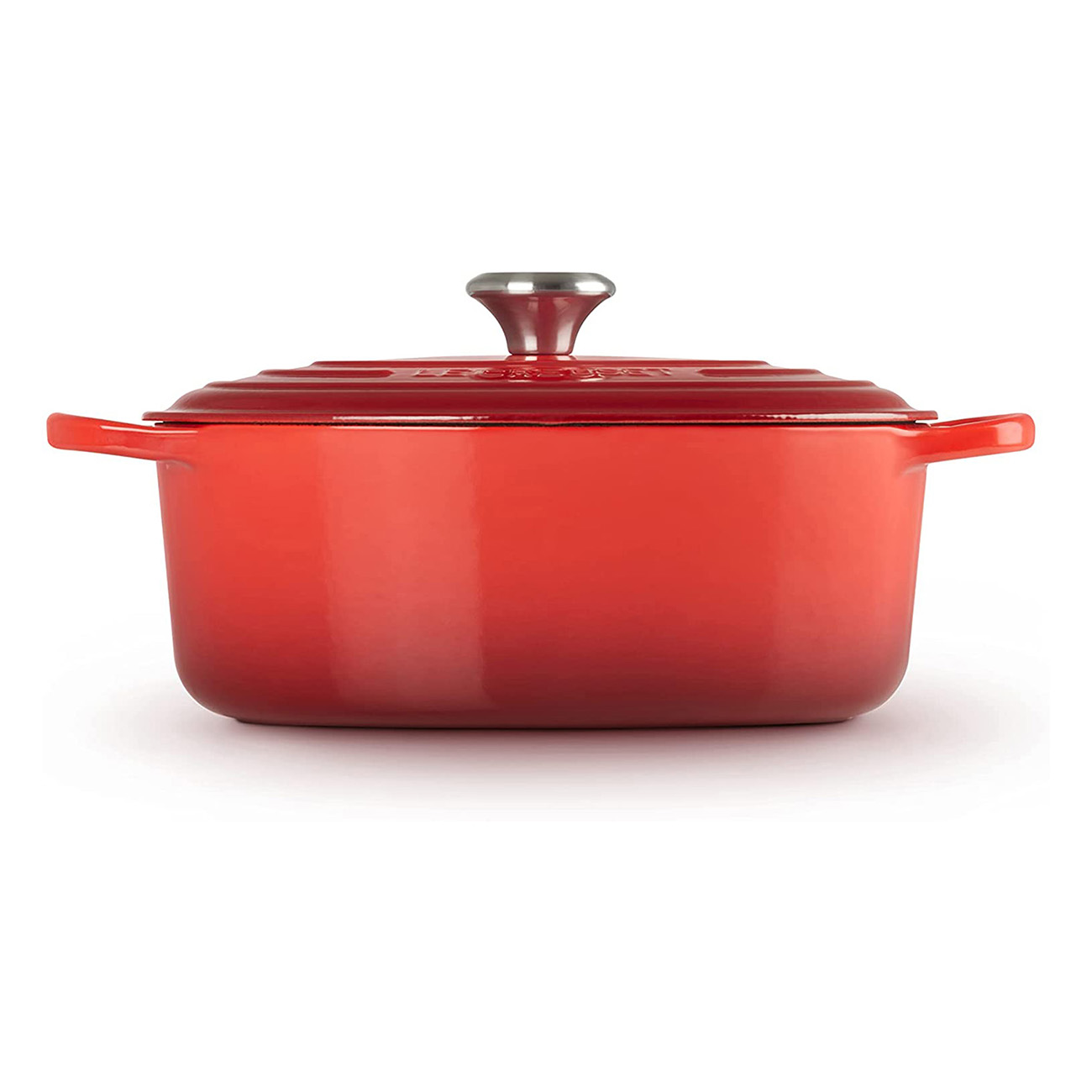 Casserole rouge Le Creuset avec couvercle sur fond blanc.