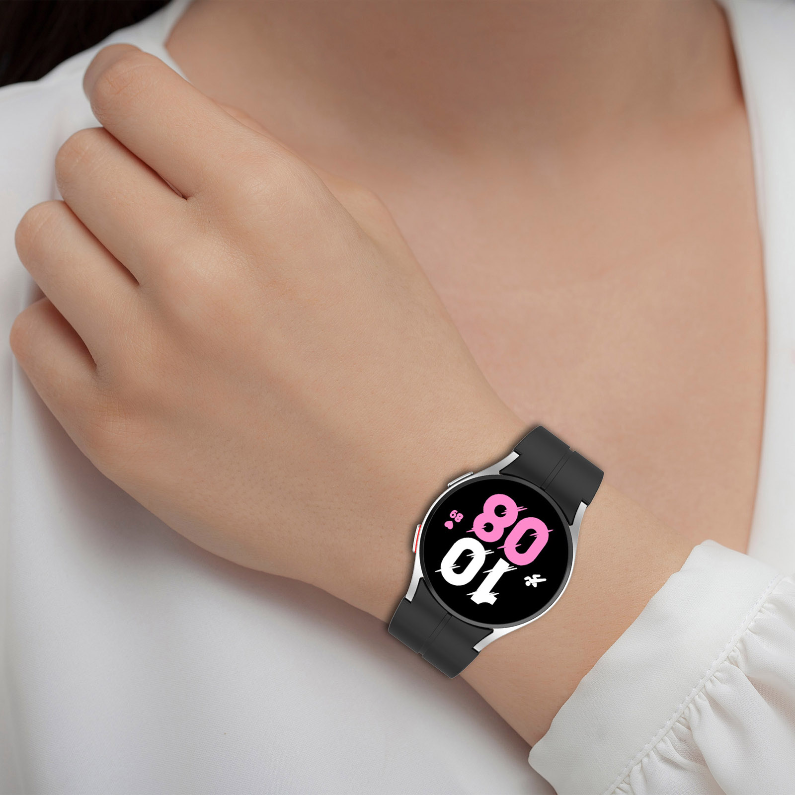 Eine Frau trägt eine schwarze Smartwatch am Handgelenk. Das Zifferblatt zeigt die Uhrzeit.