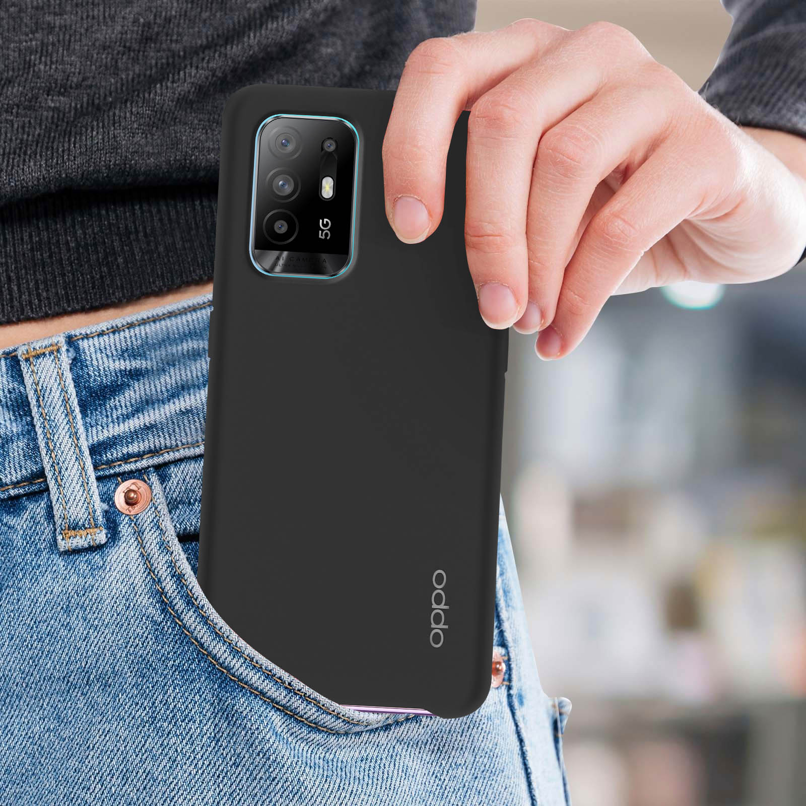 Un telefono nero è parzialmente visibile in una tasca dei jeans. Il telefono ha più fotocamere e il logo Oppo è visibile.