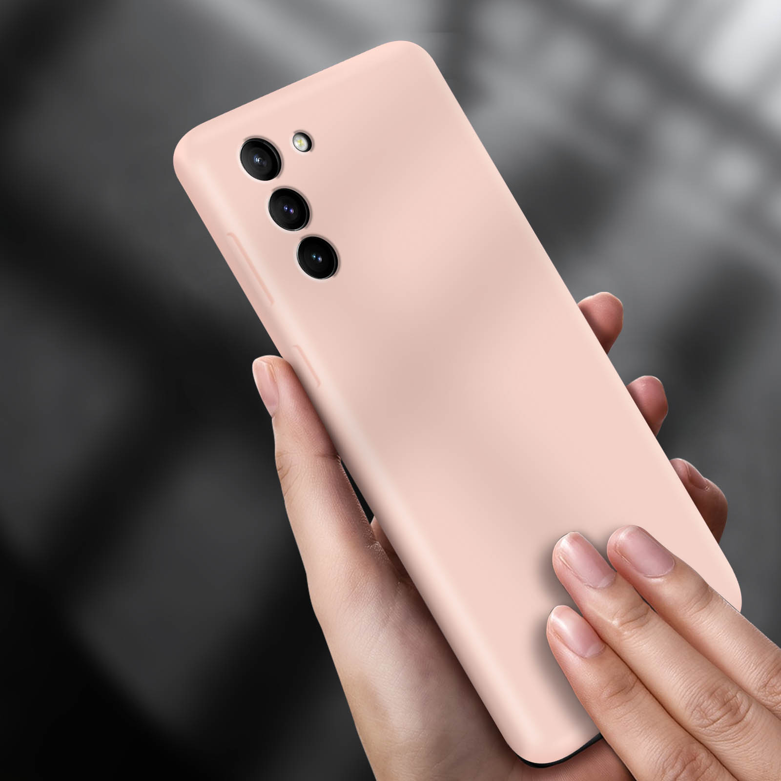 Hand hält hellrosa Telefonhülle. Das Telefon hat 3 Kameras.