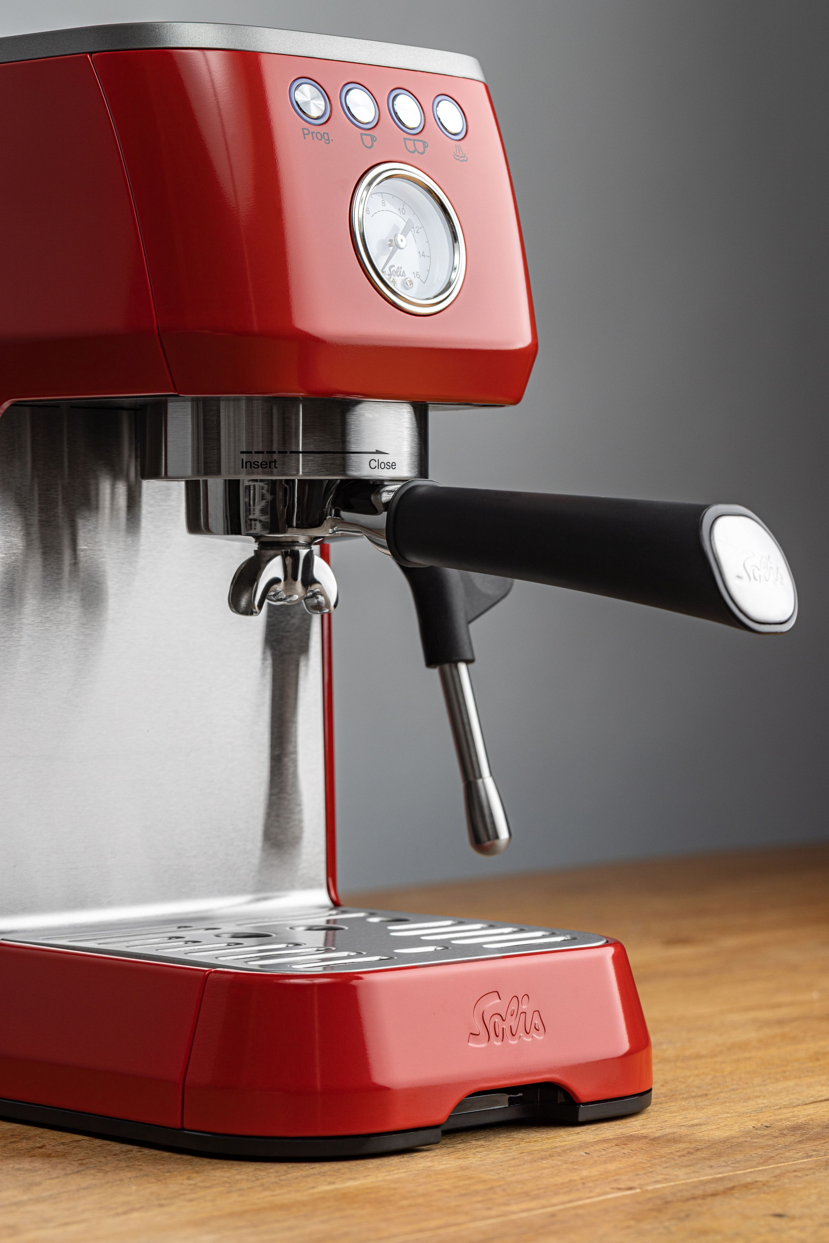 Eine rote und silberne Espressomaschine, Nahaufnahme, auf einer Holzoberfläche.