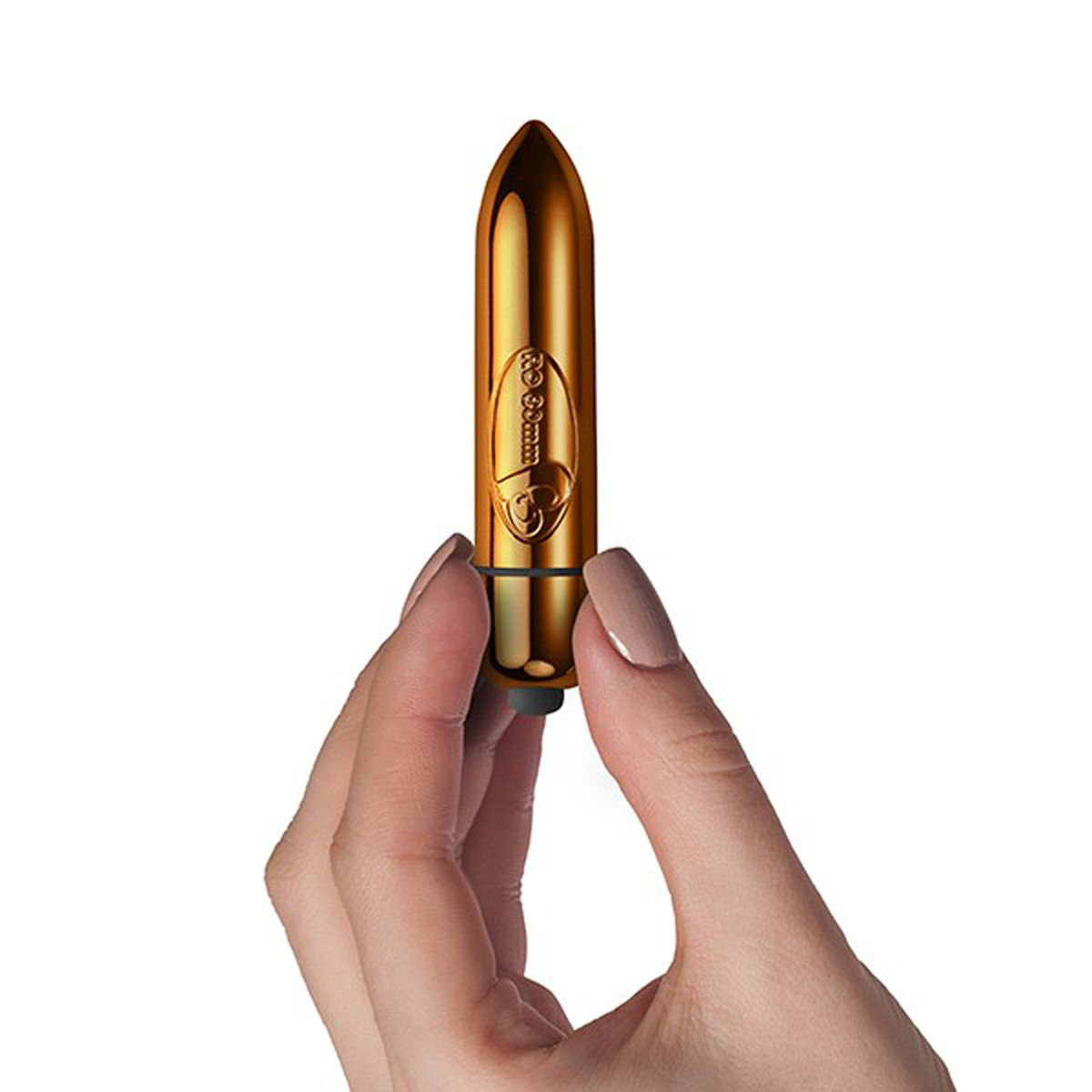 Ein goldener Bullet-Vibrator wird von einer Person gehalten. Er hat eine strukturierte Oberfläche.