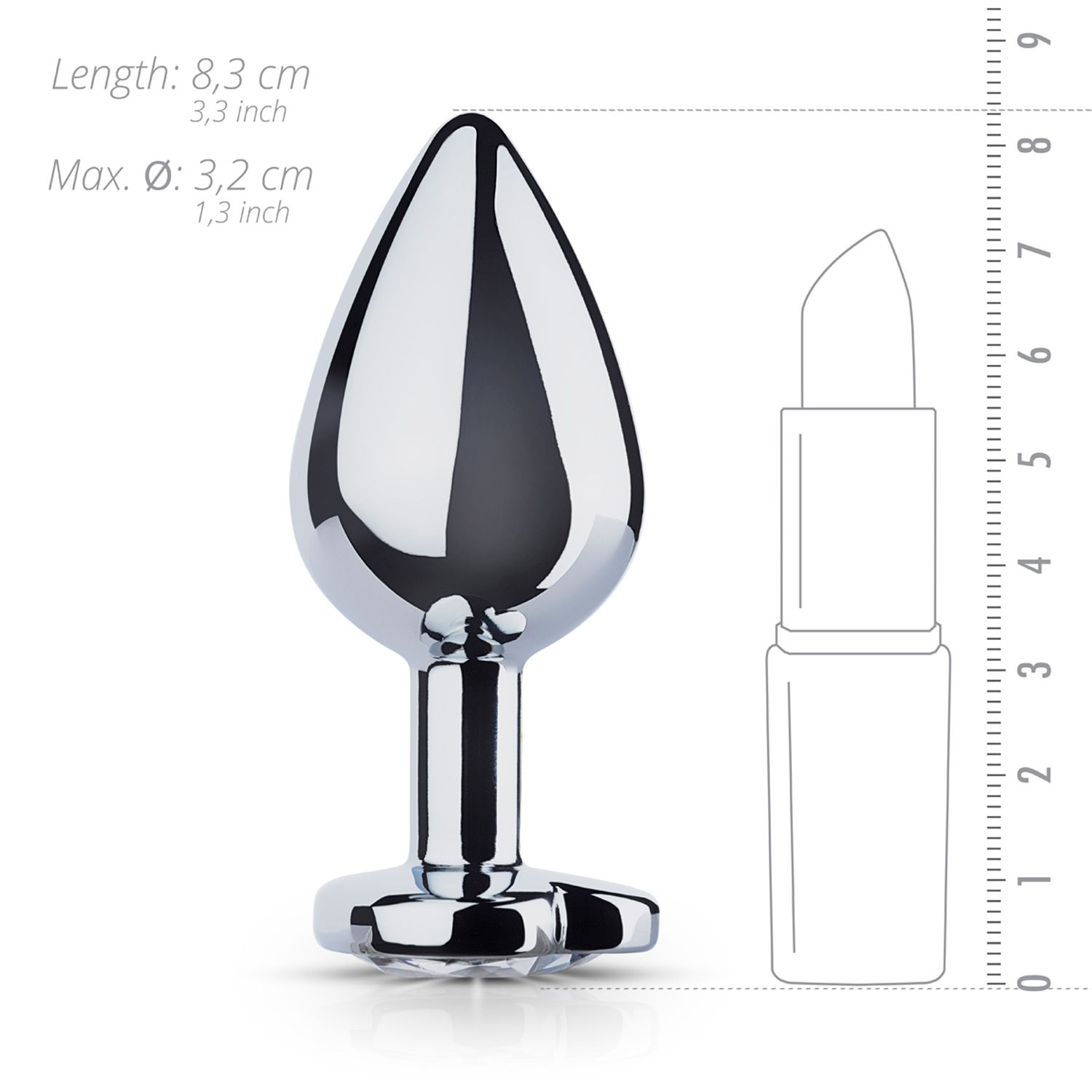 Un tapón anal plateado y brillante con forma de lágrima y una base. Un contorno de lápiz labial está al lado para la escala, junto a una regla.