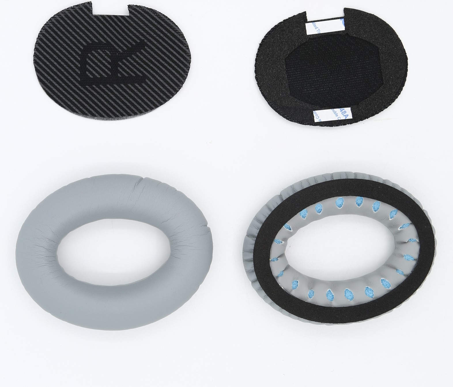 Cztery elementy słuchawek. Dwa czarne z włókna węglowego. Dwa szare, zewnętrzna część to pierścień.