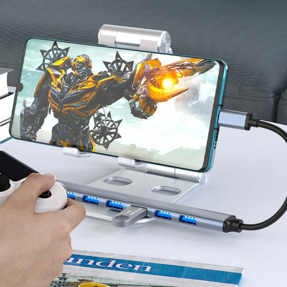 Ein Telefon mit einem Transformers-Bild ist mit einem USB-Hub und einem Gamecontroller verbunden.