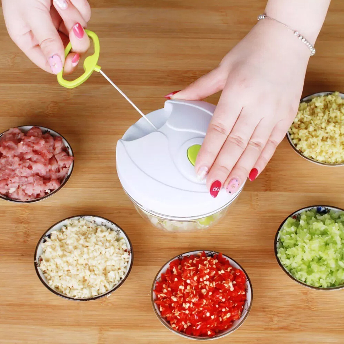 Mujer usando un picador blanco con varios ingredientes picados en pequeños cuencos sobre una mesa de madera.