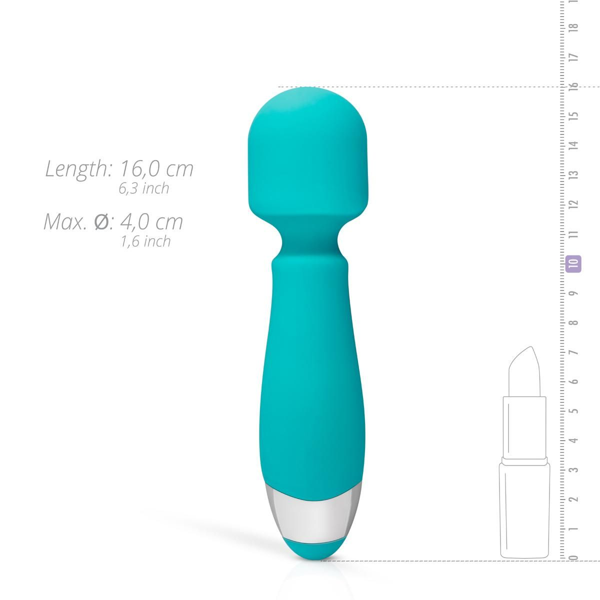 Ein türkisfarbener Vibrator mit rundem Kopf und silberner Basis wird neben einer Messskala und einer Lippenstiftkontur gezeigt.