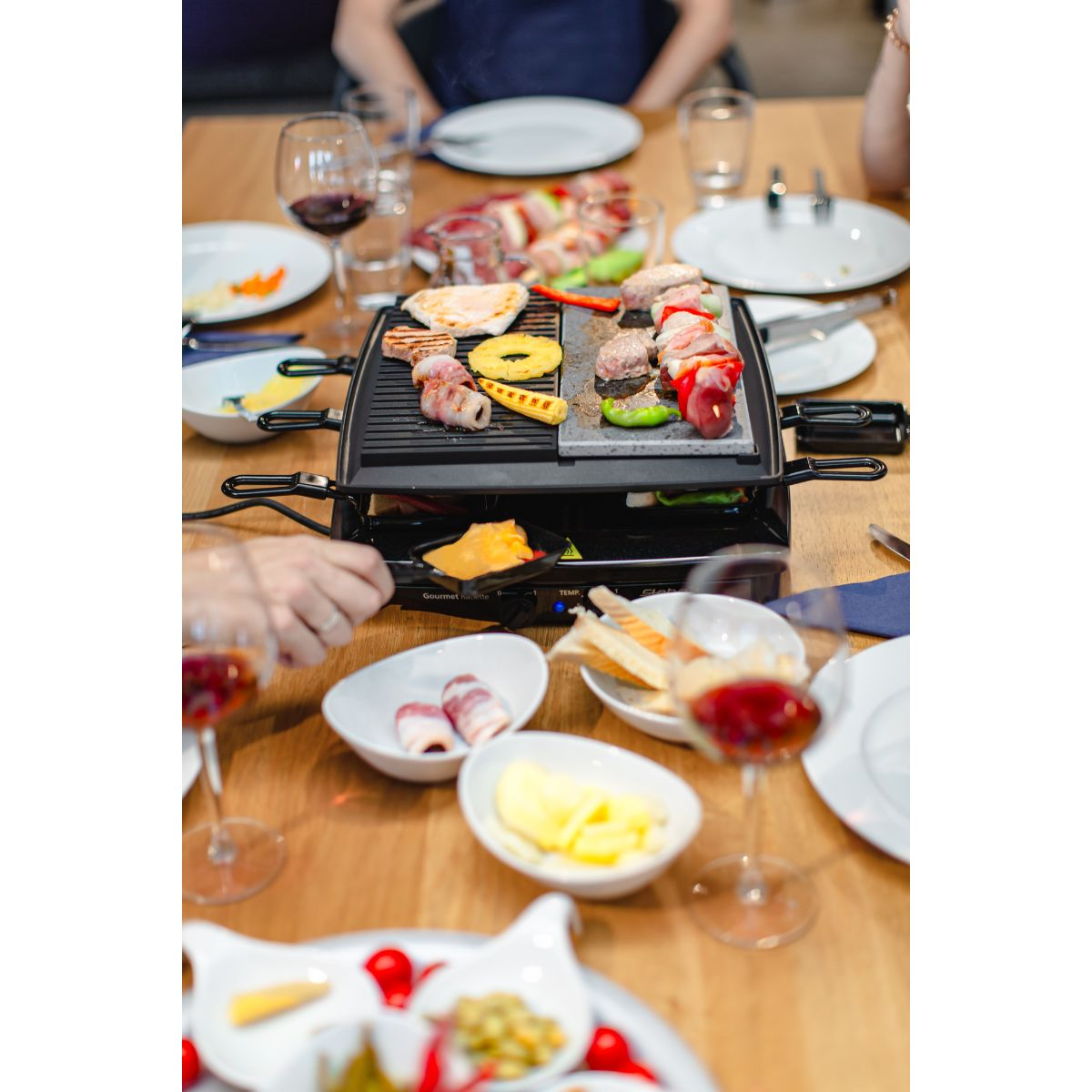 Eine Tischdekoration mit Essen und Wein, Personen sind unscharf.