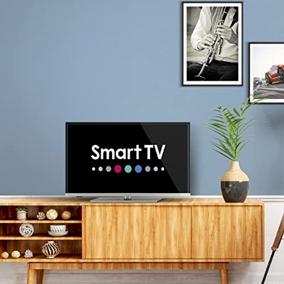Un soggiorno con una Smart TV su un mobile in legno. Opere d'arte sulla parete blu.