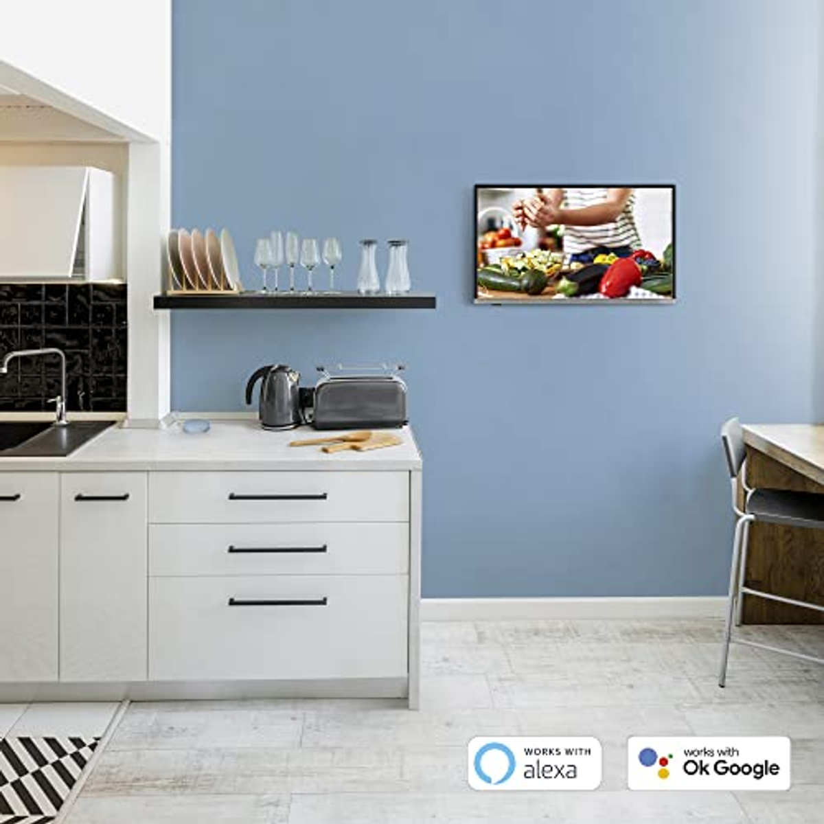Una scena di cucina con una TV che mostra qualcuno che cucina, un lavandino e elettrodomestici.