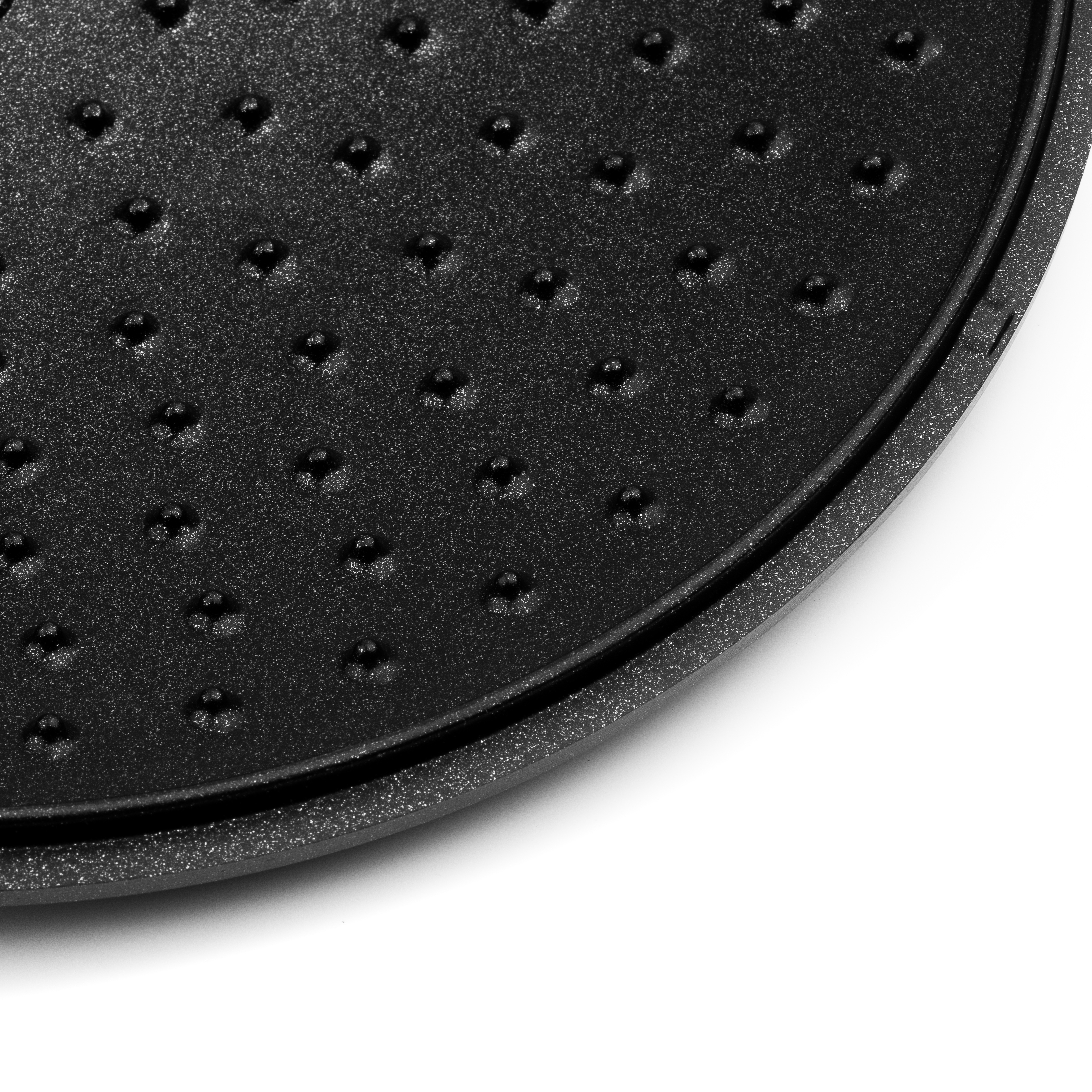 Eine schwarze, strukturierte Oberfläche mit kleinen Löchern, Nahaufnahme.