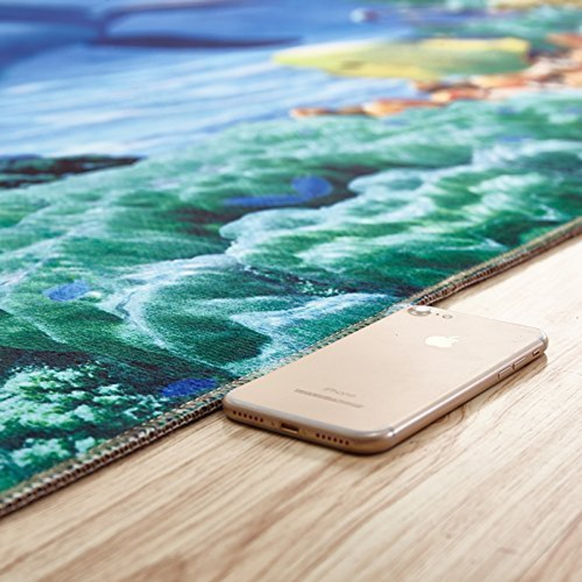 Uno smartphone su un tappeto con design oceanico, pavimento in legno.