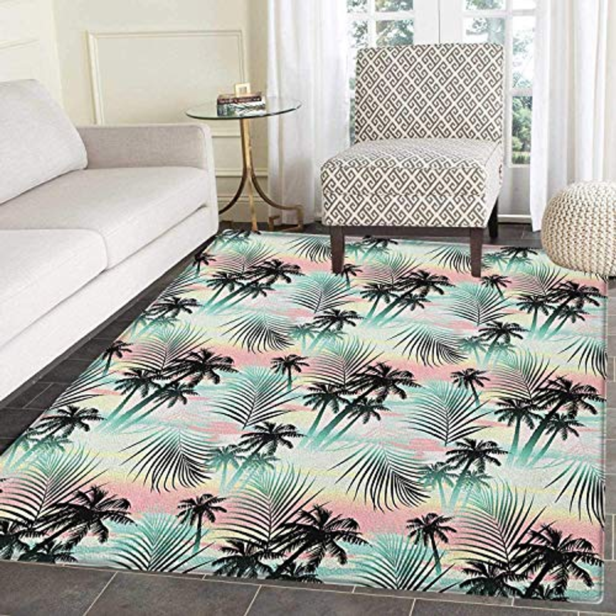 Una alfombra de temática tropical con palmeras y hojas. Está sobre un suelo de baldosas en una habitación con sofá y silla.