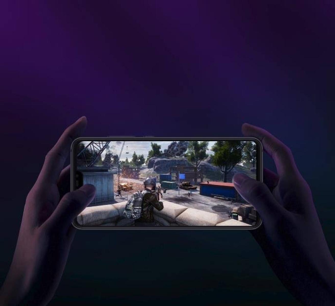Dłonie trzymają telefon z grą, scena bitwy, fioletowe tło.