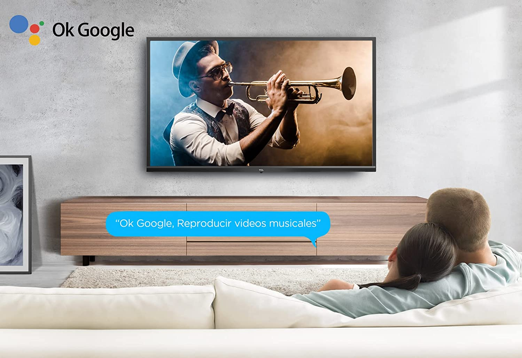 Pareja viendo la televisión con un hombre tocando la trompeta. Smart TV con un mensaje de Ok Google.
