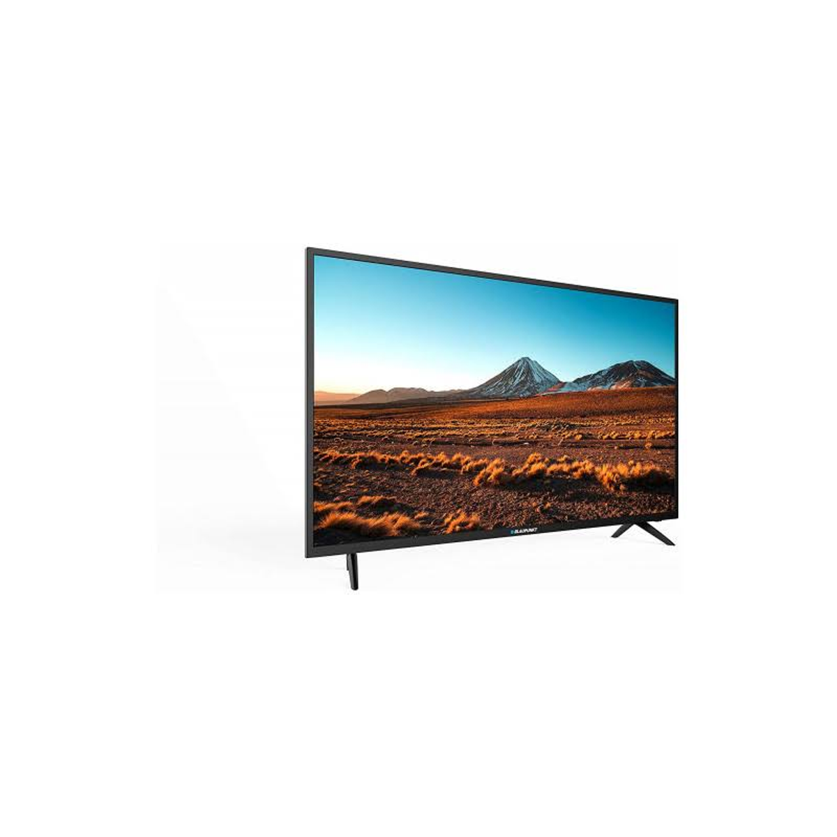 TV a schermo piatto su sfondo bianco, che mostra un paesaggio con montagne e cielo blu.