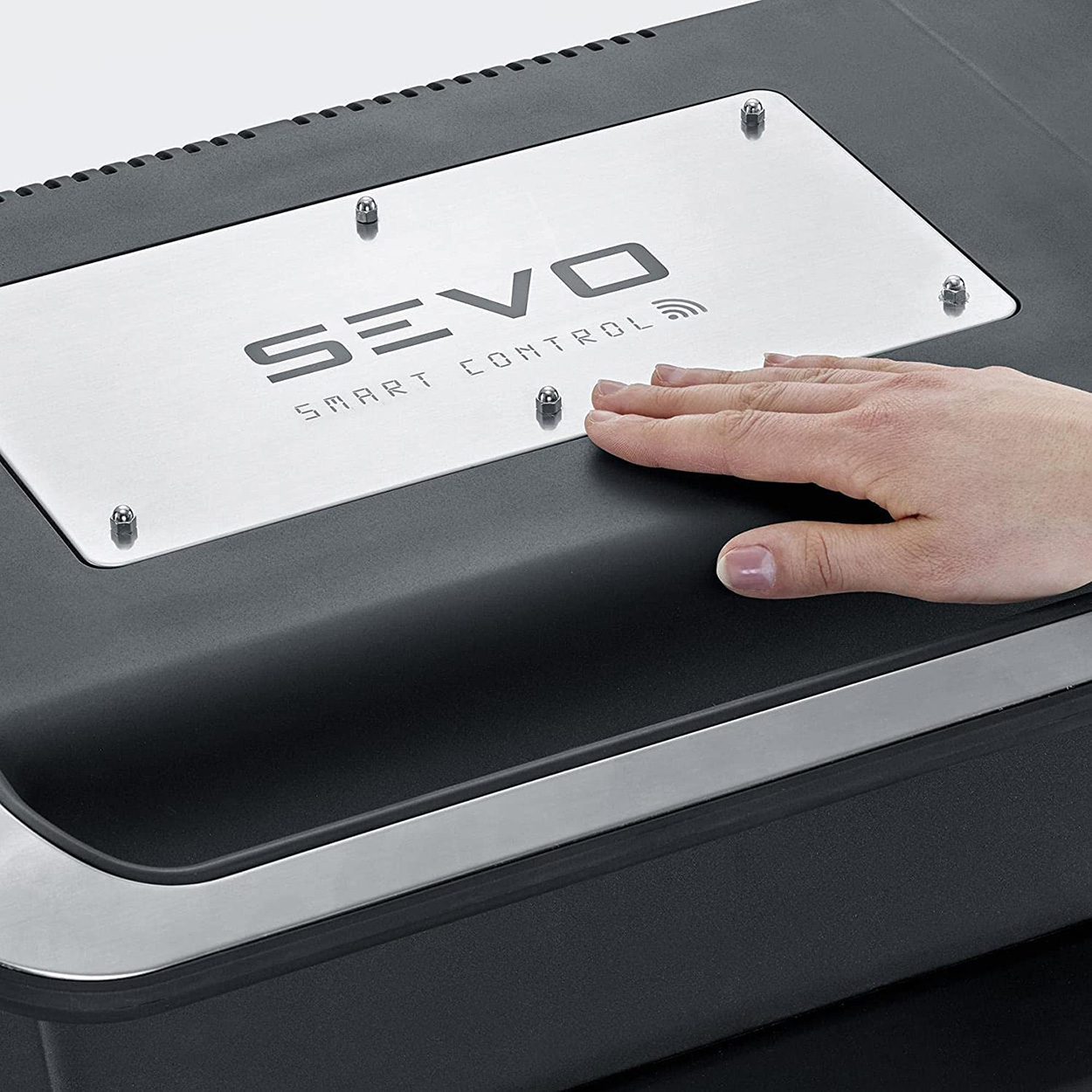 Eine Hand berührt ein schwarz-silbernes Bedienfeld. Der Text SEVO SMART CONTROL ist sichtbar.