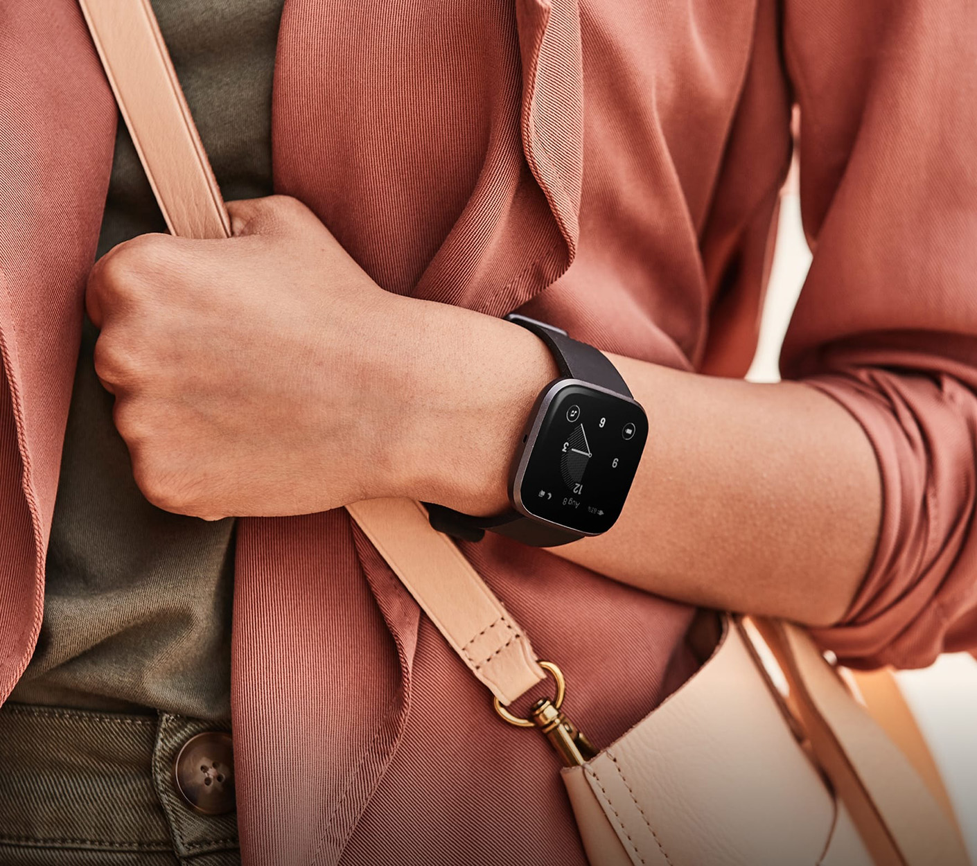 Person, die eine Smartwatch mit einem Zifferblatt trägt und eine Umhängetasche trägt.