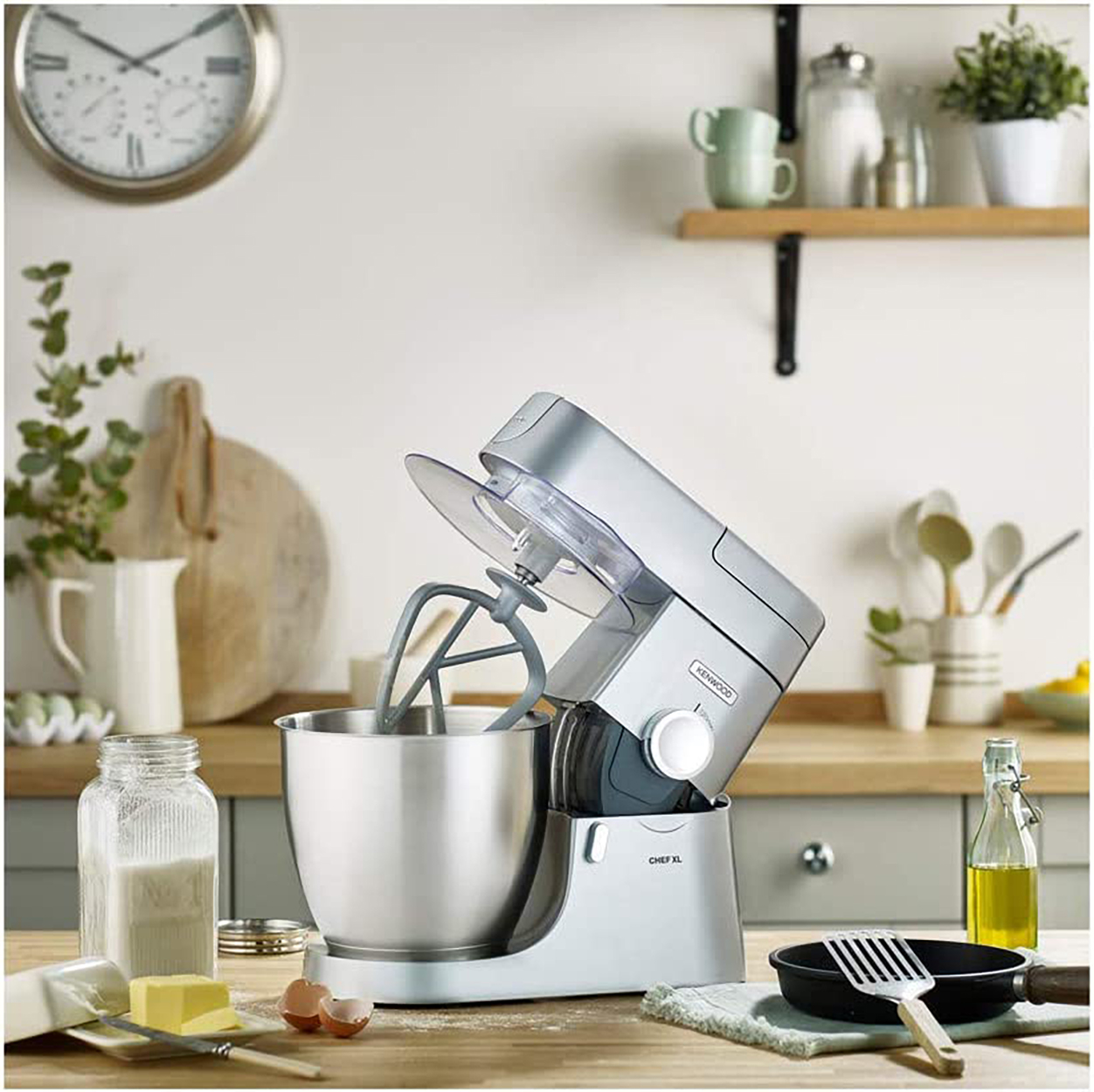 Ein Küchenmixer mit Zutaten wie Mehl, Butter und Öl auf der Theke.