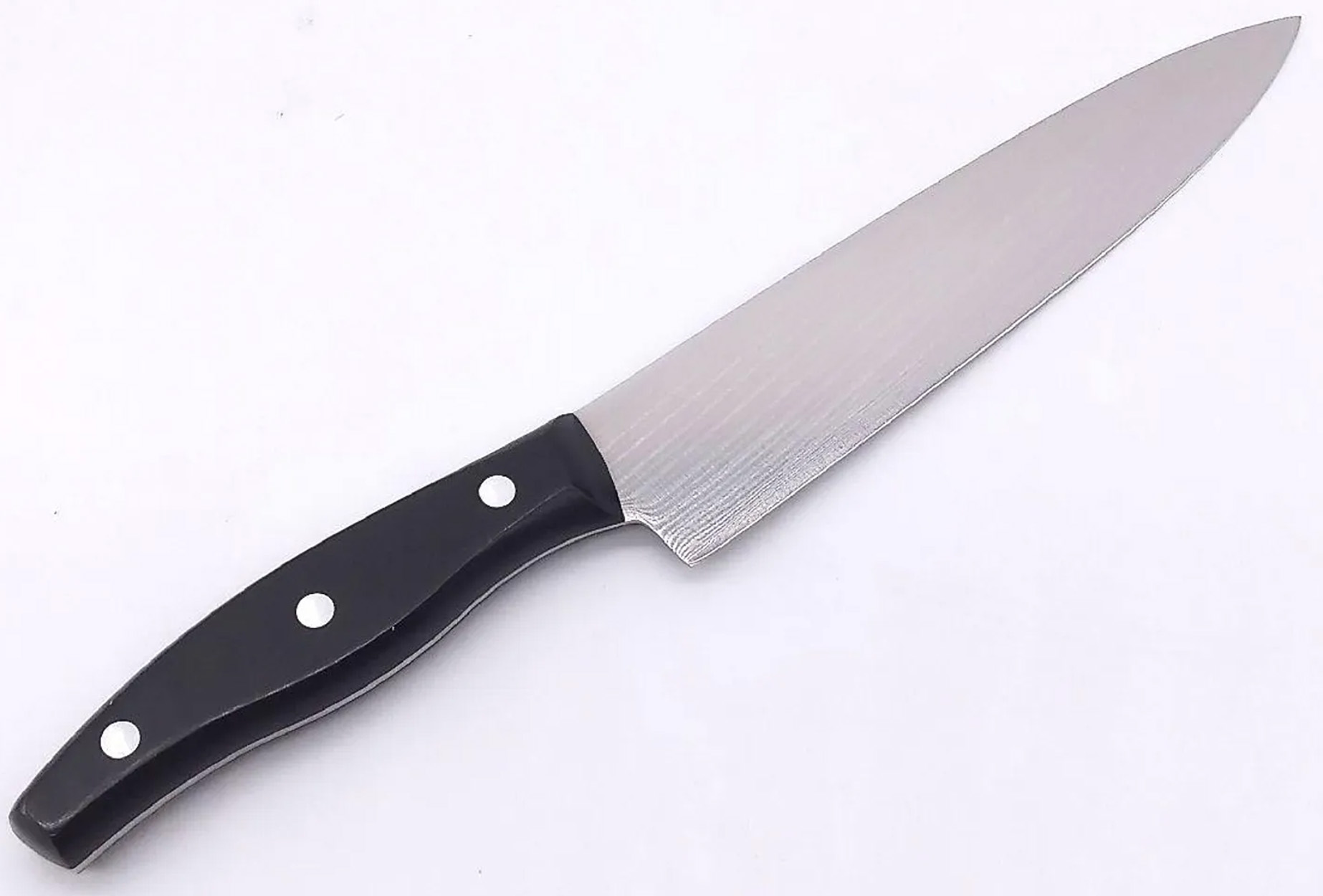 Nóż kuchenny z czarną rączką i srebrnym ostrzem. Nóż leży na białej powierzchni.