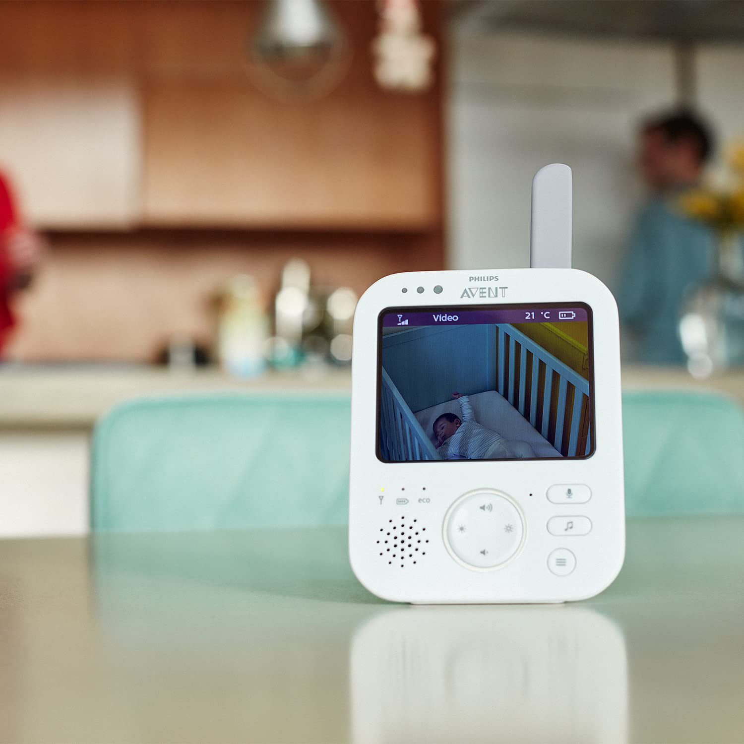 Ein weißer Babyphone zeigt ein schlafendes Baby in einem Kinderbett.
