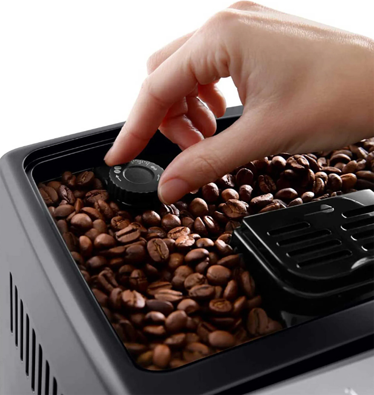 Eine Hand stellt einen schwarzen Drehregler an einem Kaffeebohnenbehälter in einer Kaffeemaschine ein.