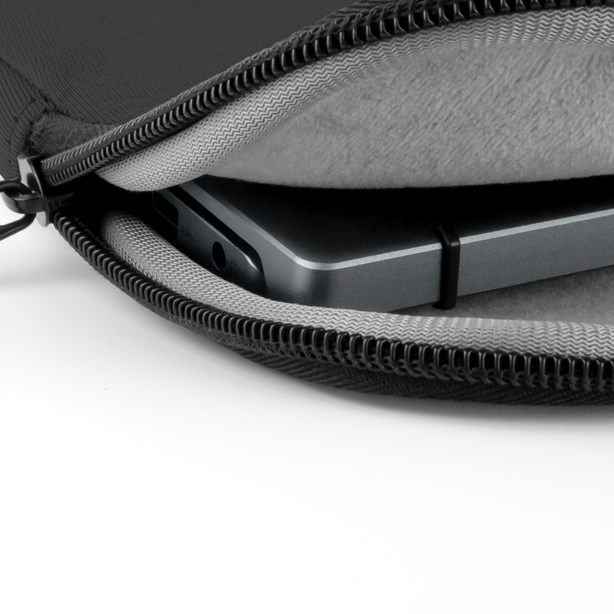 Un portátil dentro de una funda negra. La funda está abierta y es gris por dentro.