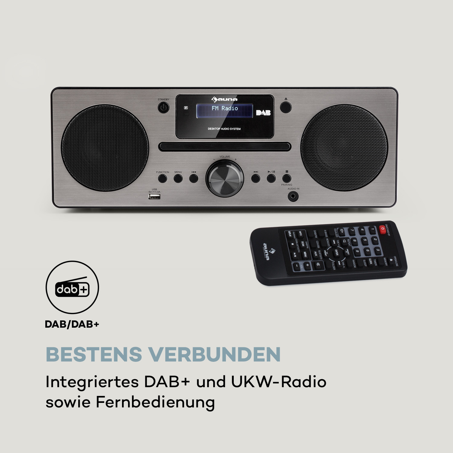 Silbernes Radio mit Lautsprechern und DAB+-Logo. Fernbedienung darunter.