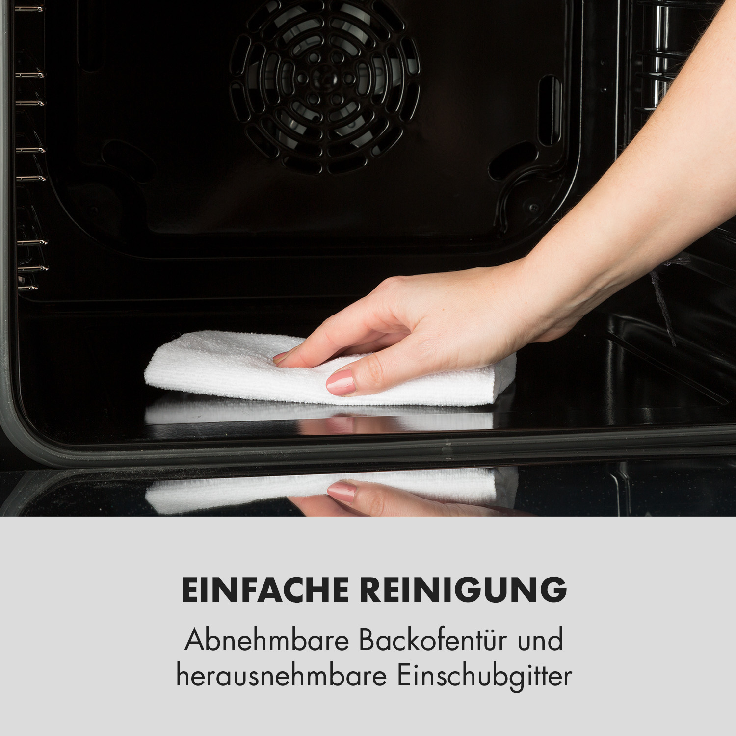 Eine Hand reinigt das Innere eines Ofens mit einem weißen Tuch.