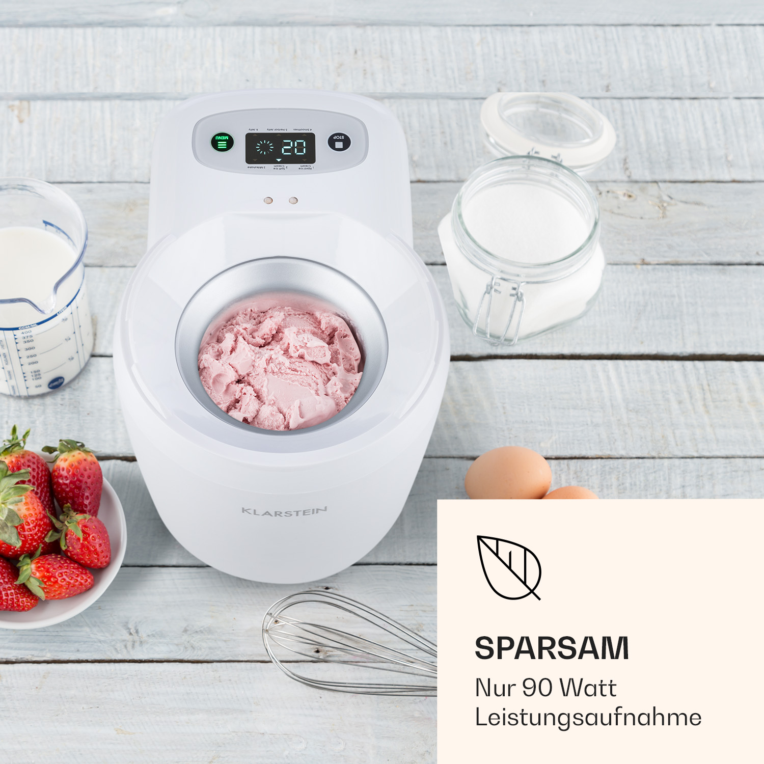 Eismaschine mit Zutaten: Milch, Zucker, Eier und Erdbeeren.