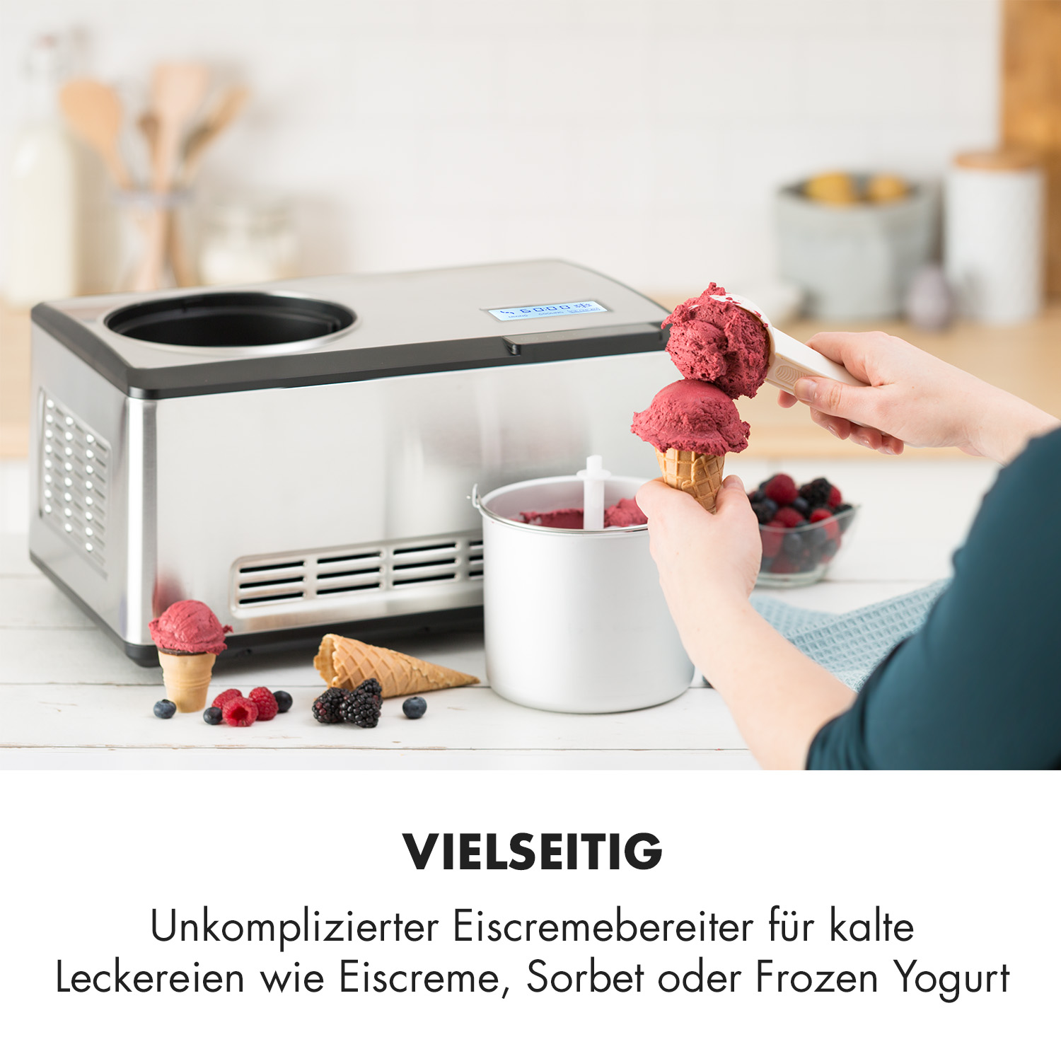 Person schöpft Eis aus einer Maschine, mit Eistüten und Beeren.