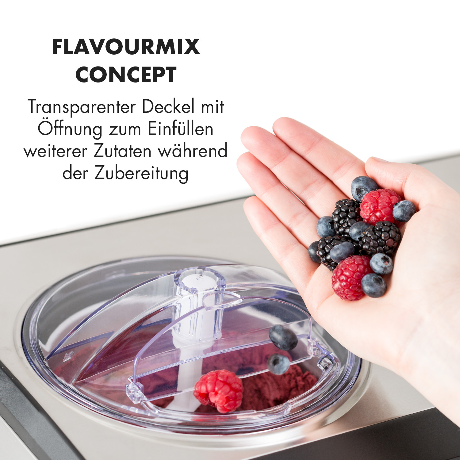 Hand hält Beeren über einem Deckel einer Eiscrememaschine. Rote und schwarze Beeren vorhanden.