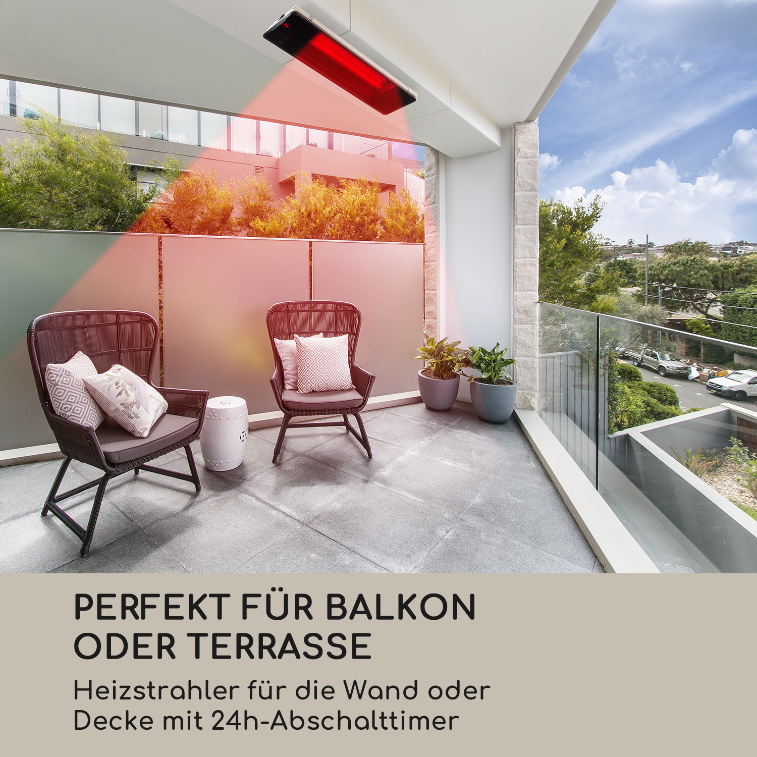 Roter Infrarot-Heizstrahler auf einem Balkon, zwei Stühle mit Kissen, Pflanzen und Aussicht.