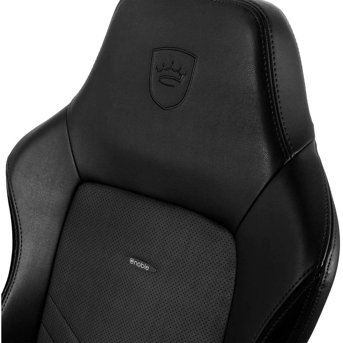 Nahaufnahme der Kopfstütze eines schwarzen Gaming-Stuhls mit Logo und Perforationen.