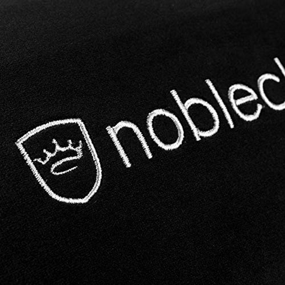 Schwarzer Stoff mit weiß gesticktem "noblechairs"-Logo und Krone.