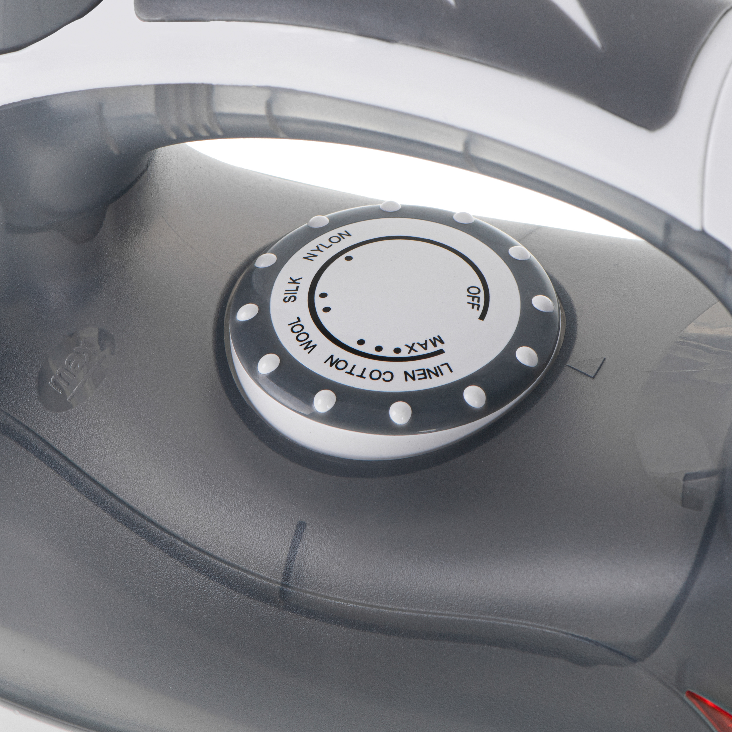 Primer plano del dial de control de una plancha, con ajustes para diferentes tejidos como seda, lino y algodón.
