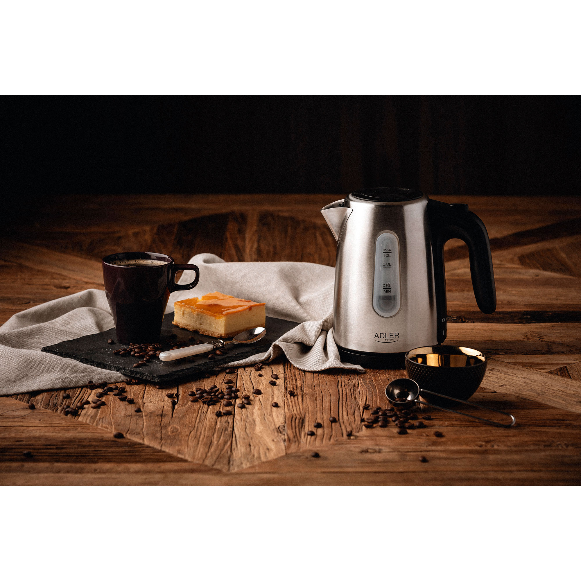 Bouilloire, café, gâteau et tasse sur une table en bois. Fond sombre.